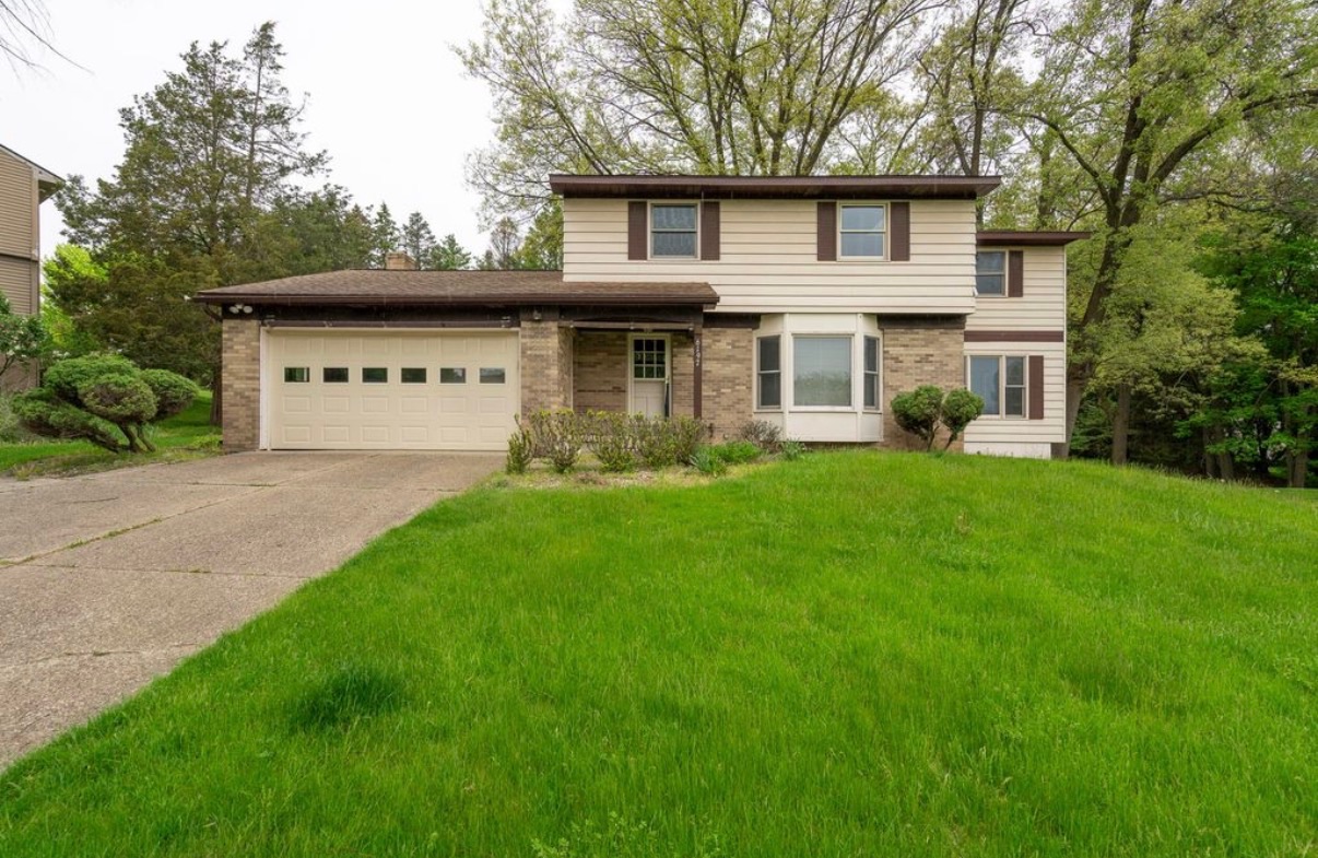 Exterior house before painting — dated beige siding with brown trim, Grand Rapids MI