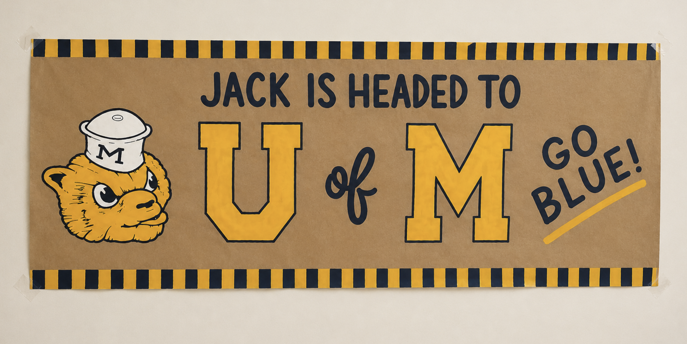Hand-painted banner — Jack is headed to U of M, with Wolverine mascot illustration