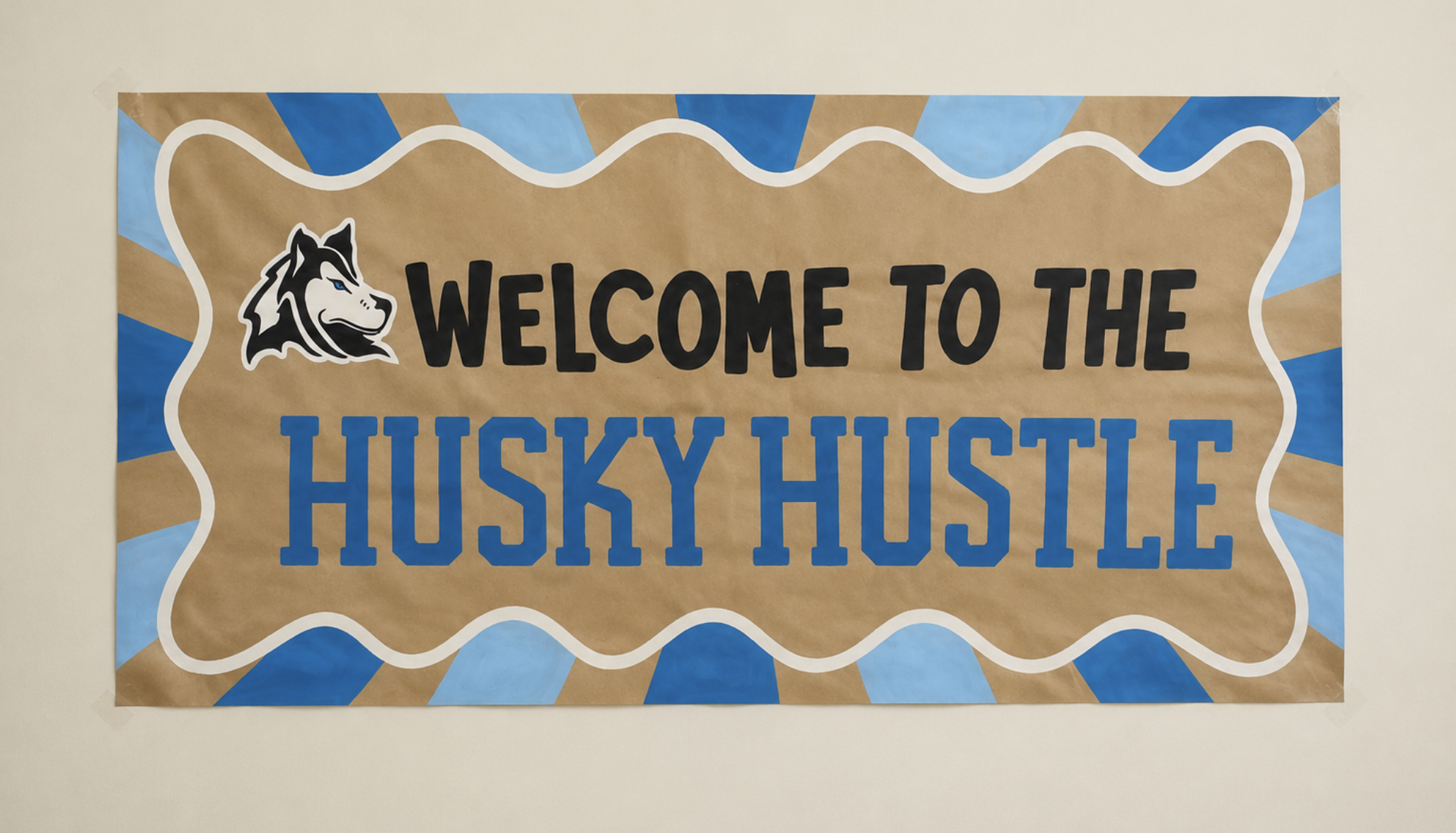 Hand-painted Welcome to the Husky Hustle school event banner in blue and kraft