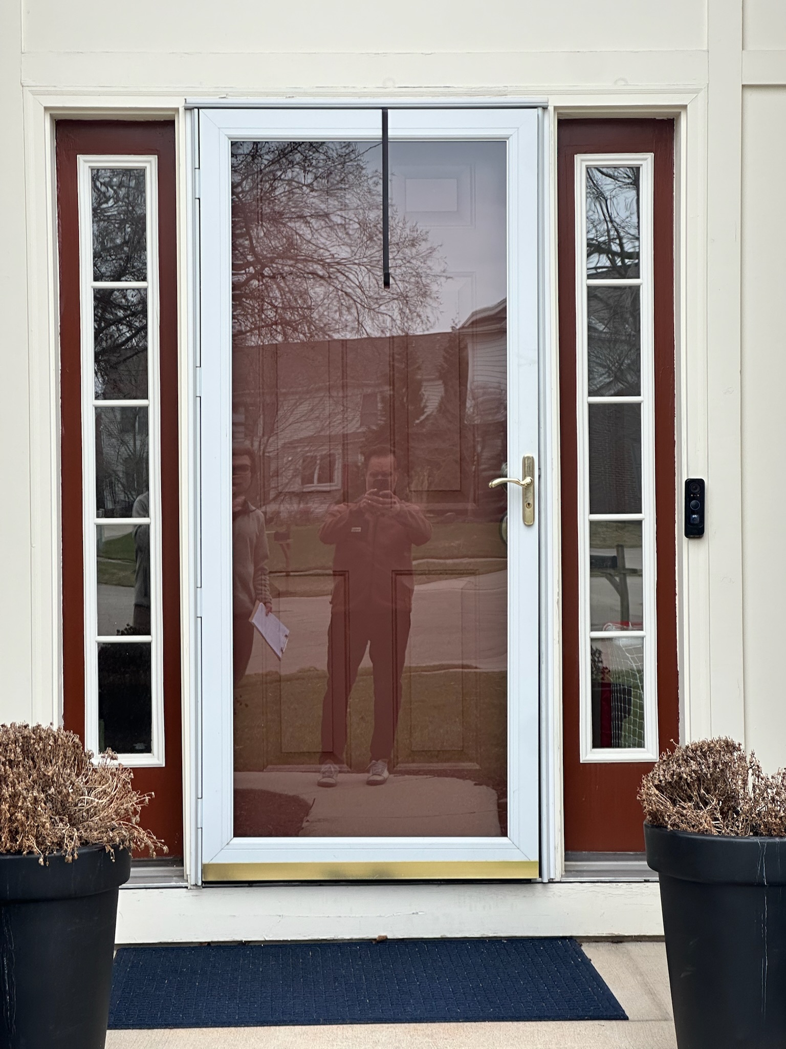 Front door before painting — dated maroon door with storm screen, Grand Rapids MI