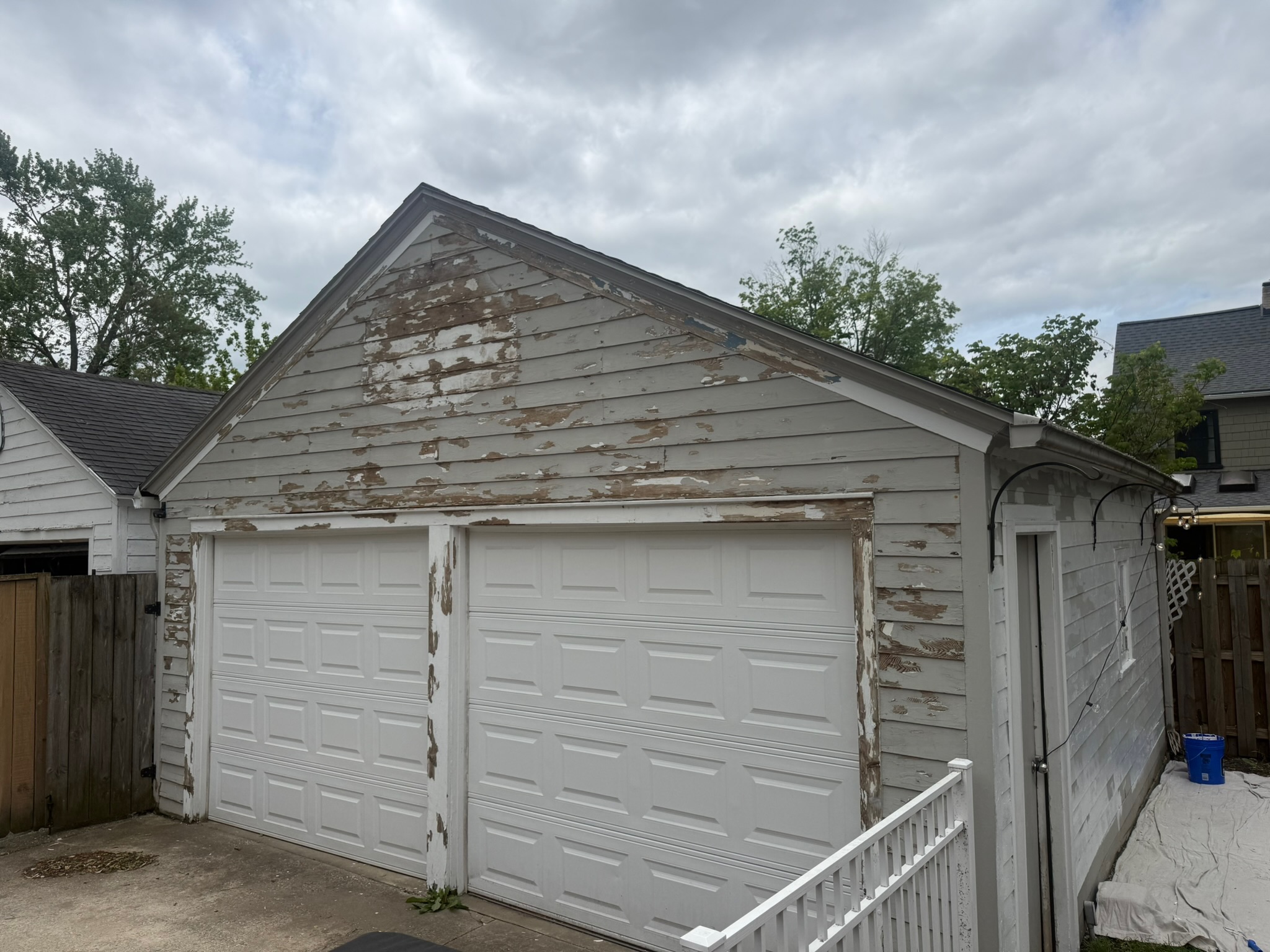 Detached garage before painting — severely peeling paint on wood siding, Grand Rapids MI